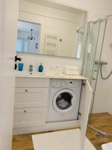 a bathroom with a washing machine and a sink at Hilltom by the Sea in Rowy