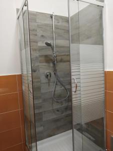 una ducha con puerta de cristal en un baño en Non ci resta che Napoli, en Nápoles