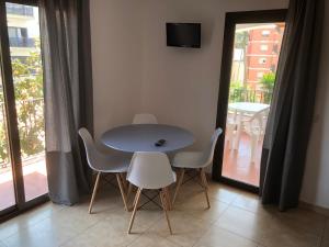 una mesa y sillas en una habitación con balcón en Apartamentos AR Caribe, en Lloret de Mar