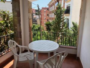 - Balcón con mesa blanca y 2 sillas en Apartamentos AR Caribe, en Lloret de Mar