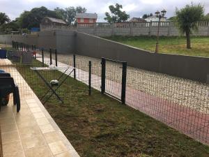 a tennis court with a net in the grass at Apartamento en Barreiros. Playa Catedrales in Barreiros