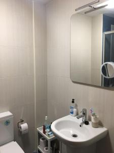 a bathroom with a sink and a toilet and a mirror at Apartamento en Barreiros. Playa Catedrales in Barreiros