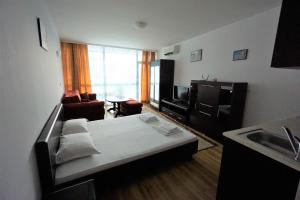 a room with a bed and a kitchen with a sink at Apartments in hotel Primorsko Del Sol in Primorsko