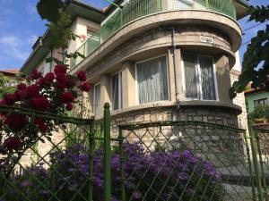una vecchia casa con una recinzione e fiori viola di Vila Venera a Velingrad