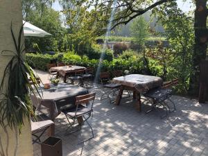 un patio con mesas y sillas en un jardín en Landhaus vor Burg Eltz, en Wierschem