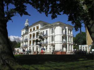 a large white building with a tower on top of it at Seeschloß Heringsdorf - Villa aus Gründerzeiten in Heringsdorf