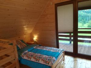 1 dormitorio con 1 cama en una cabaña de madera en "U Kamińskich" en Przyborów