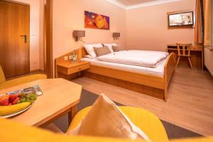 una camera d'albergo con letto e tavolo con cesto di frutta di Pension Silberbauer a Lohberg