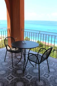 einen Tisch und Stühle mit Meerblick in der Unterkunft Hotel Terrazzo Sul Mare in Tropea