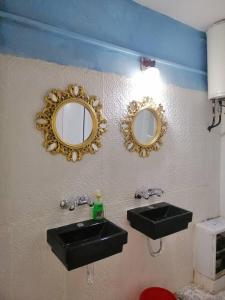 a bathroom with two sinks and mirrors on the wall at Bunksurfing Hostel in Bethlehem