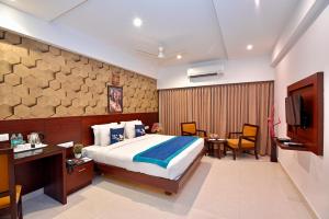 a hotel room with a bed and a television at I V Sanctum Hotel in Bengaluru +56 photos
