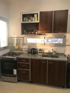 a kitchen with wooden cabinets and a stove top oven at Departamento 2 ambientes sobre el río Paraná Con Cochera in Corrientes