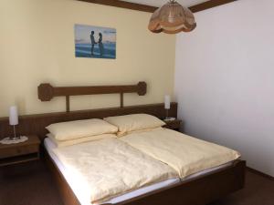 1 dormitorio con 1 cama y una pintura en la pared en Gasthof Koller en Mariasdorf