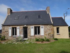 a brick house with a table and chairs in a yard at La Fermette de TREGASTEL, classée 3 étoiles in Trégastel