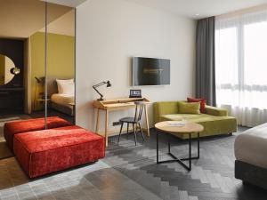 a hotel room with a bed and a couch and a table at east Hotel Hamburg in Hamburg