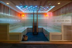 a sauna with benches and lights in a room at Ruhr Inn Hotel in Hattingen