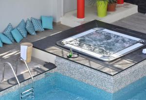 a hot tub in the middle of a swimming pool at Hôtel Arles Plaza in Arles