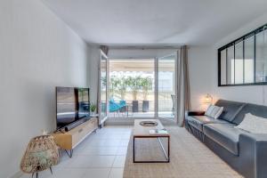 a living room with a blue couch and a tv at Appartement Palais Milton in Cannes