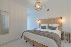 a bedroom with a large bed and a chandelier at Appartement Palais Milton in Cannes