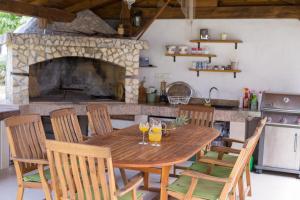 einen Holztisch in einer Küche mit Kamin in der Unterkunft Rooms Stolfa in Krk