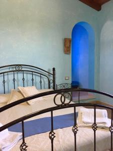 um quarto com uma cama com uma parede azul em I Carrubi em San Priamo