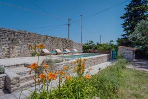 a backyard with a swimming pool and a stone wall at Unique Antistress Oasis Villa Antiqua in Osor