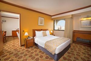a hotel room with a bed and a window at Ramada by Wyndham Bahrain in Manama