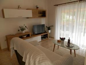 un soggiorno con divano, tavolo e TV di Apartment Slavica a Lozovac
