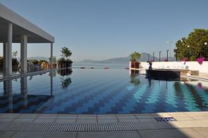 ein Schwimmbecken neben einem Gewässer in der Unterkunft Kaunos Hotel in Koycegiz