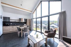 a kitchen and living room with a table and chairs at Panoramabungalow _70_ im Feriendor in Truppach