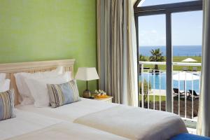 a bedroom with a bed and a balcony with the ocean at Cascade Wellness Resort in Lagos