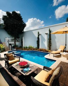 a patio with a table and chairs and a swimming pool at Casa Azul Monumento Historico in Mérida