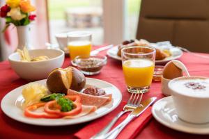 a table with plates of food and glasses of orange juice at Pension Haas-Hotel am Turm in Rottweil