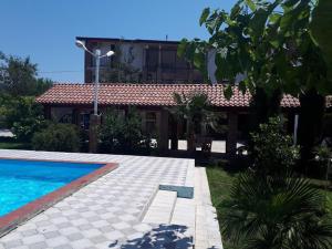 a house with a swimming pool in front of a house at Shaloshvili's Cellar Hotel in Shilda