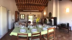 a dining room with a green table and chairs at Villa Gaia in Seggiano