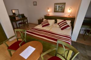 マリアーンスケー・ラーズニェにあるセント ゲオルグ ガルニのベッドルーム1室(ベッド1台、椅子2脚、テーブル2台付)