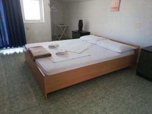 sypialnia z łóżkiem z białą pościelą i poduszkami w obiekcie Apartmani Kovačić w mieście Murter