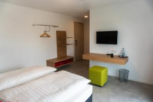 a bedroom with a bed and a tv on a wall at Pension Haas-Hotel am Turm in Rottweil