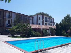 a swimming pool in front of a building at Shaloshvili's Cellar Hotel in Shilda