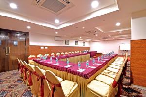 a conference room with a long table and chairs at I V Sanctum Hotel in Bengaluru