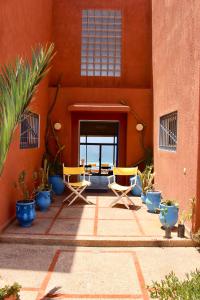 a patio with chairs and potted plants in front of a building at Panoramica Atlantic Villa Souss-Massa in Rbat