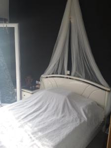 Una cama blanca con dosel en un dormitorio en Paradise City studios, en Loutraki