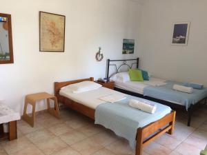 a bedroom with two beds and a table and a chair at Villa Costa Studios in Vathi