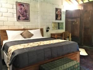 a bedroom with a bed and a table with a chair at Kubu Taru in Sidemen