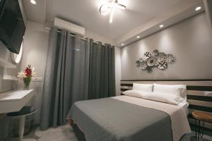 1 dormitorio con cama, lavabo y TV en Kavaki Studios en Mykonos