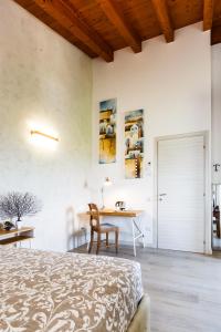 a bedroom with a bed and a desk and a table at B&B ARMONIE DI CAMPAGNA in Galliera Veneta