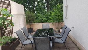een buitentafel en stoelen op een patio bij Rheinblick 3-Zimmer Apartment in Mainz