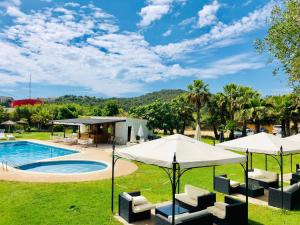 a resort pool with umbrellas and lounge chairs at Bungalows Papalus in Lloret de Mar