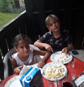 a boy and a girl sitting at a table with food at Bouffée d Oxygène in Le Seignus