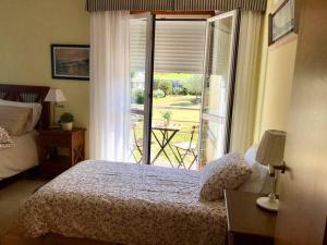 a bedroom with a bed and a window with a patio at Casa Pío Nigrán, vistas Islas Cíes in Nigrán